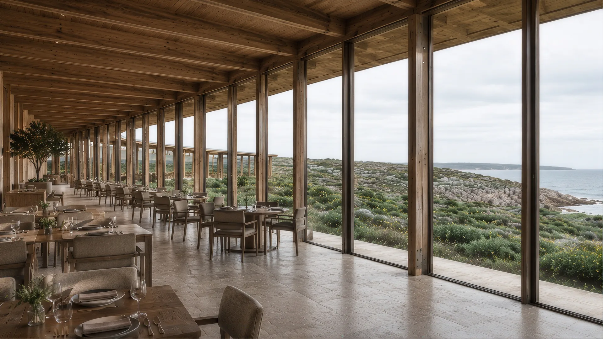 Long timber dining room with full-height glazing onto the coastline