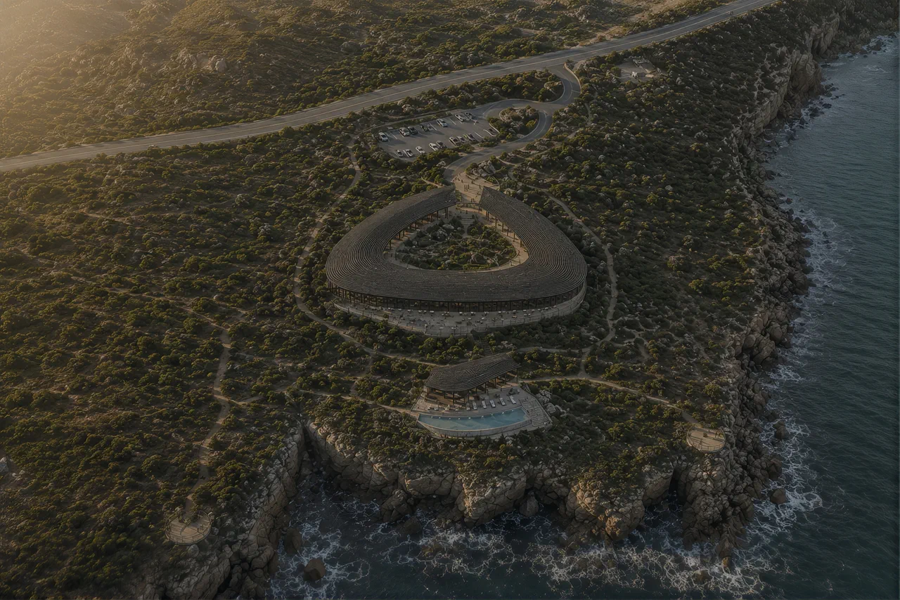 Aerial view of a curved building set into the scrub above a rocky coastline