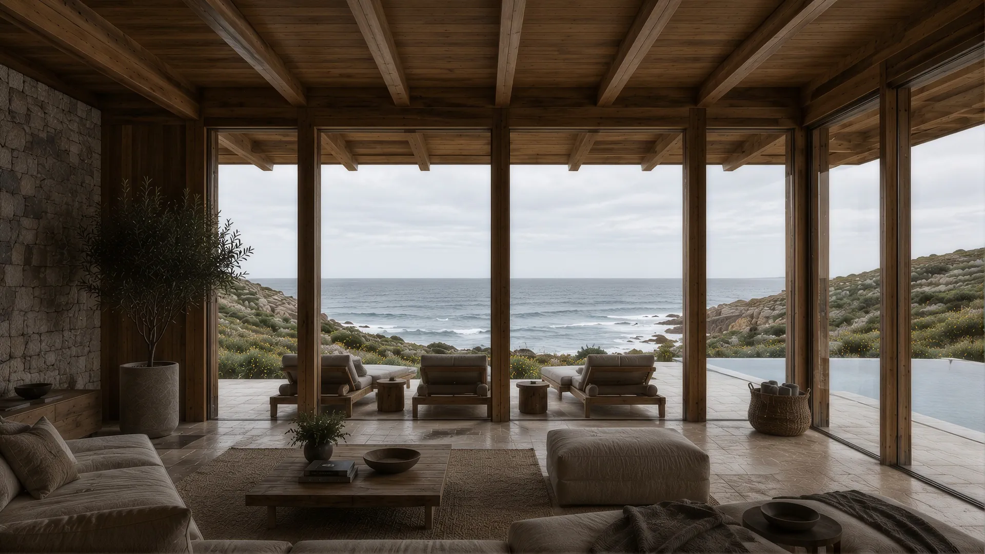 Stone and timber living room opening onto a terrace facing the sea