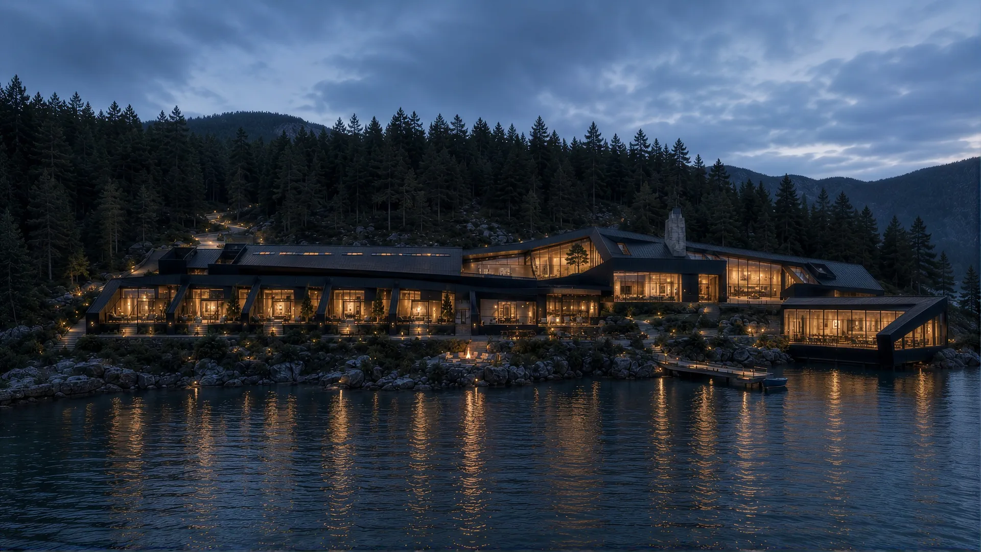 Lit timber buildings stepping down a forested shoreline to a lake at dusk